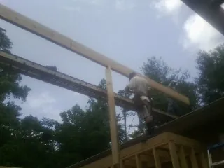 Carpenter setting a ridge beam over a new addition frame — Ice Dam Removal by Roofing Brothers in Brooten