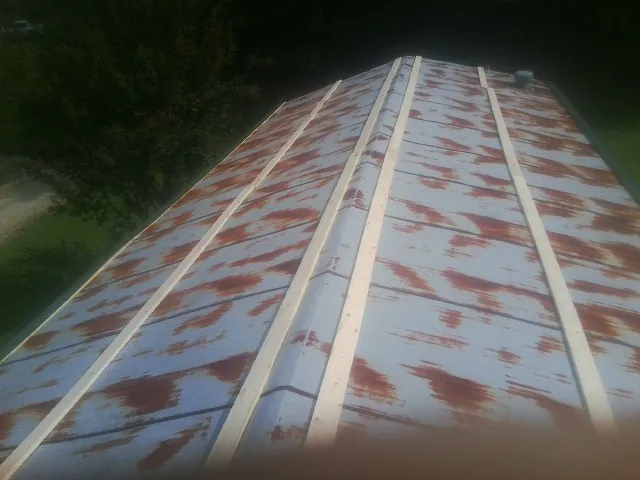 Rusted metal roof panels with new wood purlins before replacement — Storm Damage Roof Repair in Brooten by Roofing Brothers
