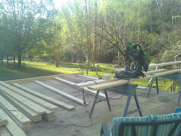Miter saw and framing lumber on a deck under construction in Brooten