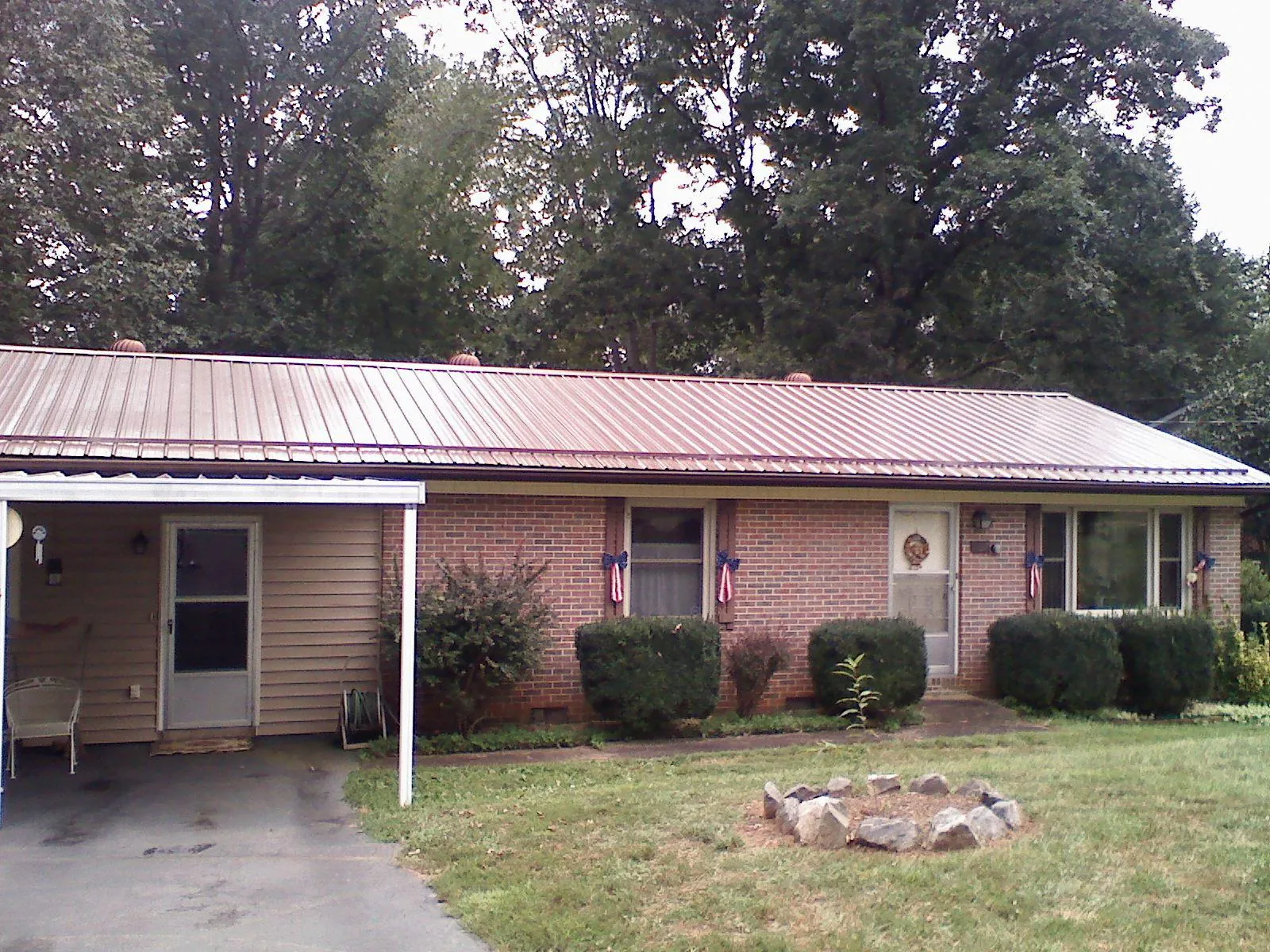 Bronze metal roof and carport on a brick ranch home — Roof Repair work by our crew in Brooten